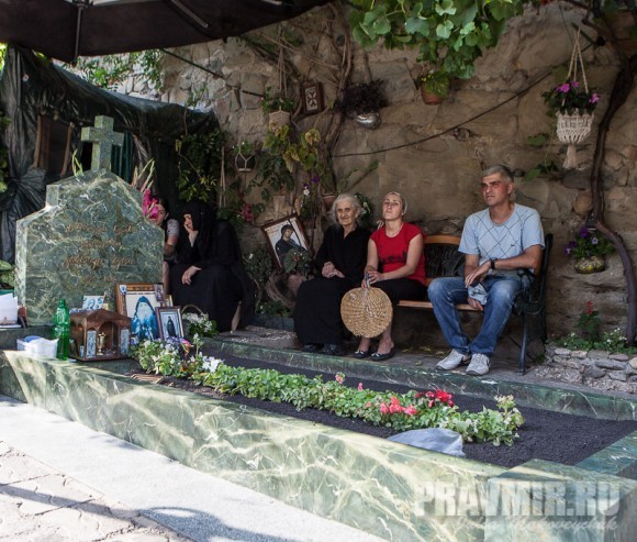 Люди, сидящие у могилы. Фото Юлии Маковейчук.