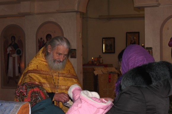 После литургии отец Игорь раздает всем кусочки просфоры