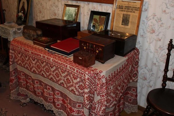 Стол с различными подарками и святынями, застеленный вышитой княгиней Шаховской скатерью