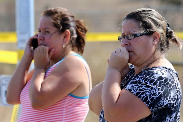 Two woman wait outside Umpqua Community College campus after a shooting at the school in Roseburg, Ore., on Thursday, Oct. 1, 2015. (AP Photo/Ryan Kang)