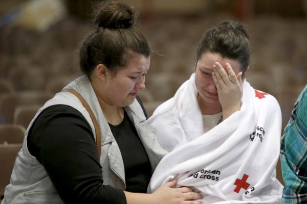 Hannah Miles, right, sits with her sister Hailey after Hannah was reunited with her family in Roseburg, Ore., on Thursday, Oct. 1, 2015, after a deadly shooting at Umpqua Community College. (Andy Nelson/The Register-Guard via AP) MANDATORY CREDIT