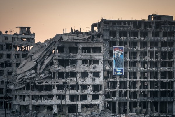 Плакат в поддержку Асада на разрушенном торговом центре в Хомсе,центр был построен, но так и не открылся. Сирия, 15 июня 2014-го. Для большинства сирийцев — это символ победы над боевиками сопротивления, но европейцы воспринимают это изображение с ровно противоположным смыслом