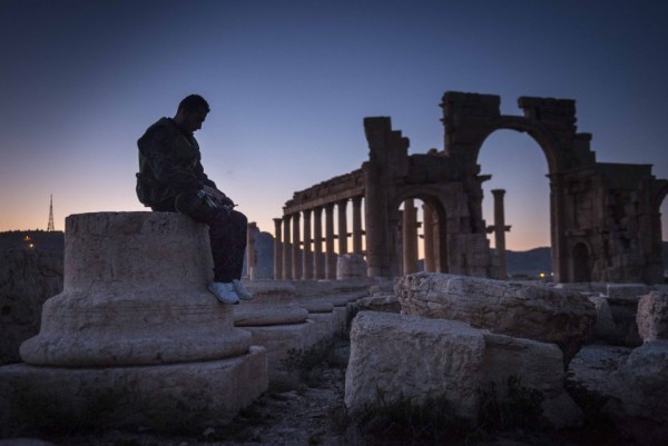 Солдат правительственных войск сидит на восточной части колоннады в разрушенной Пальмире