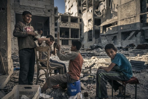Сирийский дети играют, отдыхая в перерывах между сбором металлолома