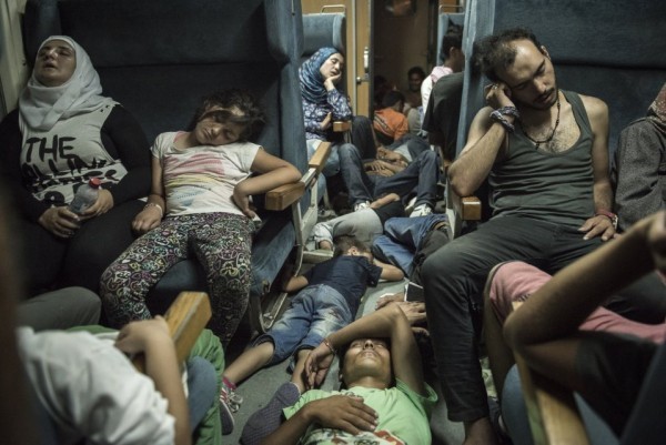 Беженцы спят в поезде, который везет их через Македонию от границы Сербии на юге до греческой границы на севере