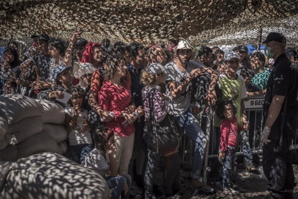 Беженцы стоят в очереди за документами в приемном центре для беженцев