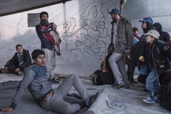 Мигранты стоят рядом с самодельной картой Европы в приемном центре для беженцев Мориа