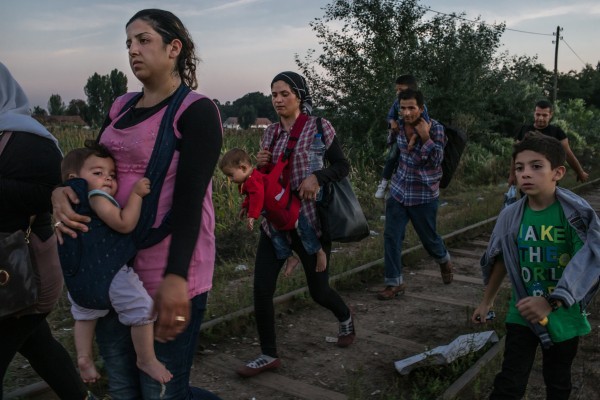 ©Maurício Lima/www.pulitzer.org Ружин Шейхо из Сирии (слева) несет свою дочь Видад, а ее сын Наби (справа) шагает вместе с другими беженцами вдоль железнодорожных путей до пересечения границы с Венгрией в сербском Хоргосе.