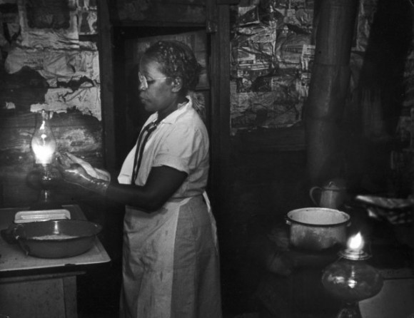 Мод готовится к работе на кухне, при свете лампы. 