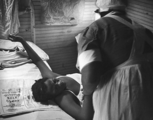 Корчась от жуткой боли, семнадцатилетняя мать шепчет молитвы, а миссис Гадсден держит ее за руку.