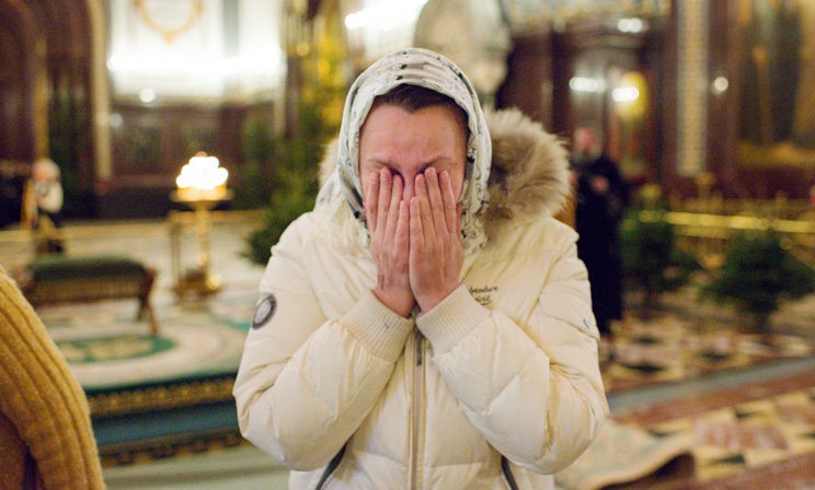 Женщина плачет от умиления и радости, что выстояла очередь и дошла до Даров