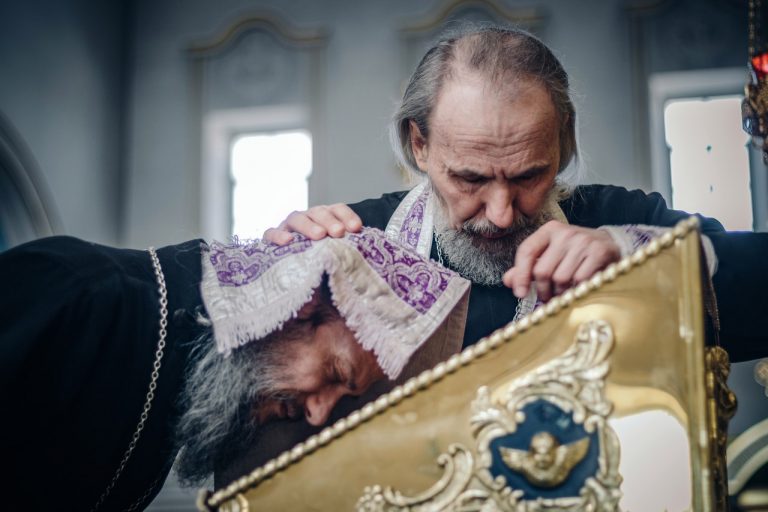 Священник держит крест