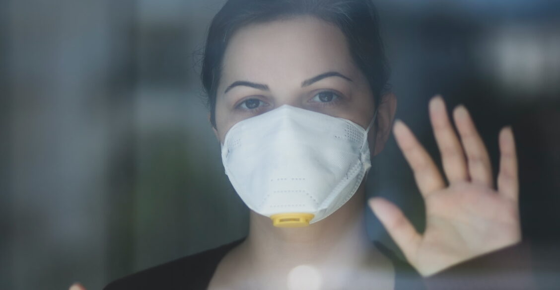 Девушка в маске за стеклом