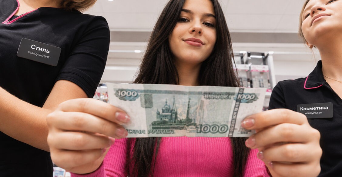Девочка-подросток в магазине держит в руках свои карманные деньги